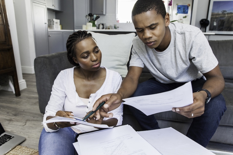 Young african female and male couple at home working on their finances together.