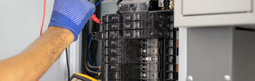 An electrician testing the electrical panel