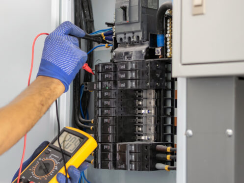 An electrician testing the electrical panel
